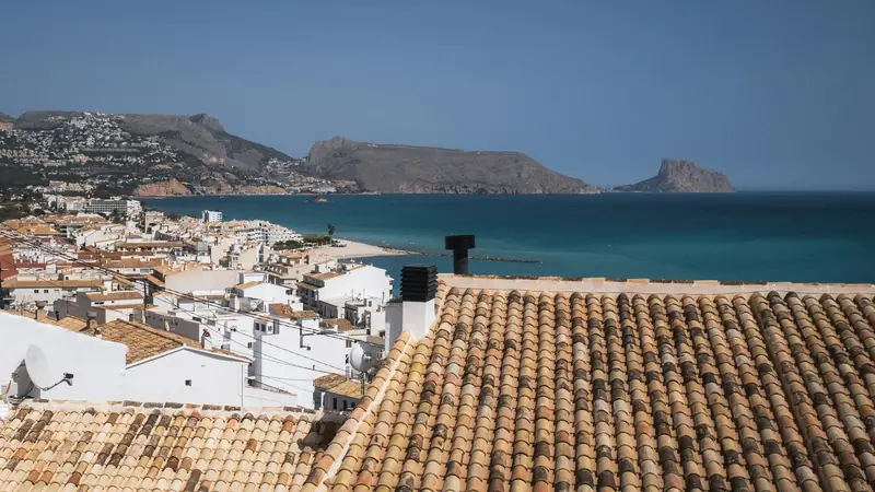Uitzicht over de witte huizen en dakpannen van Altea op de Middellandse Zee en de rotskust van de Costa Blanca